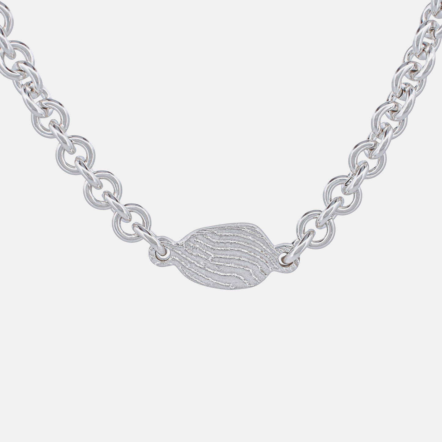 Silver chain necklace with a small, detailed pendant on a white background