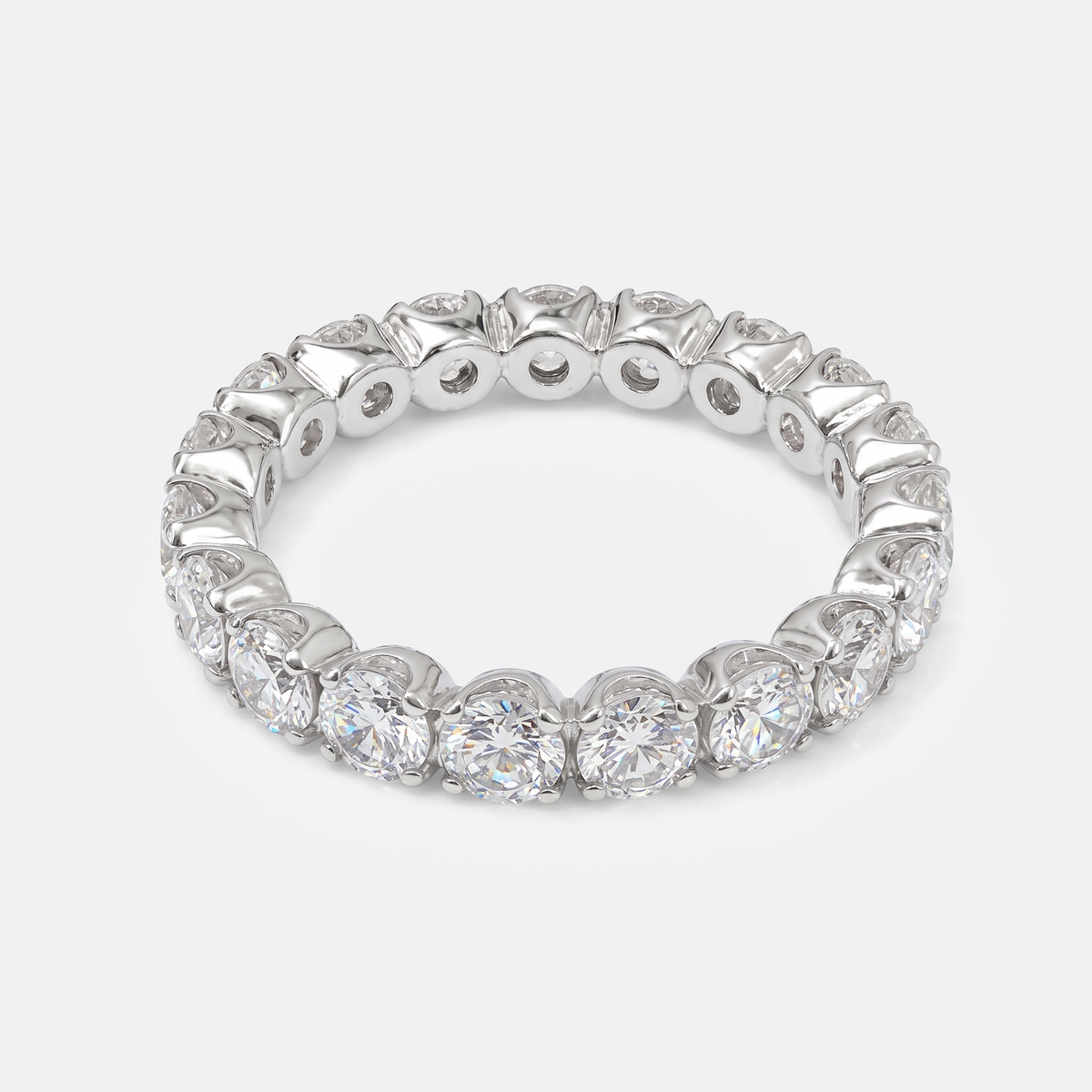 A silver-toned eternity ring featuring a continuous row of round brilliant-cut diamonds in a prong setting, shown on a light gray background.