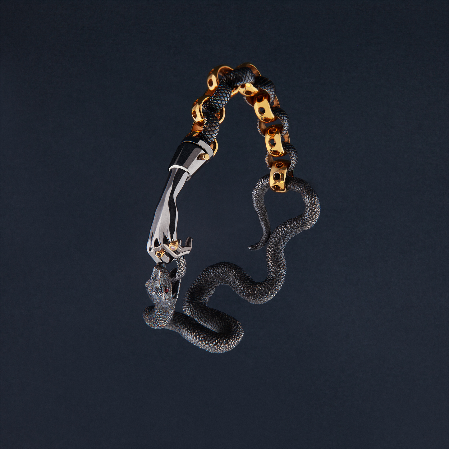 Sculptural snake bracelet in black and gold with hand detail, artistic jewellery design