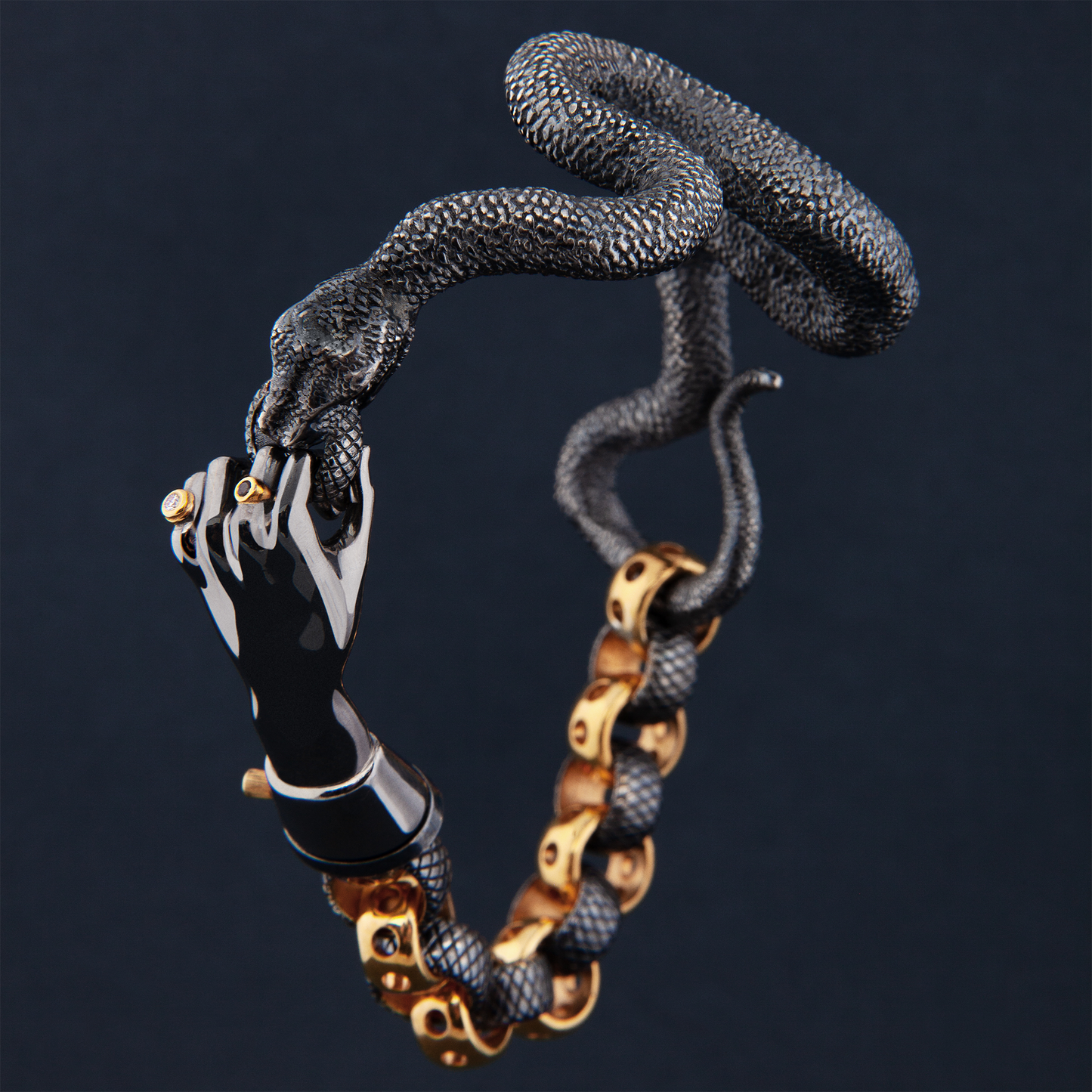 Close-up of snake bracelet with hand clasp in black and gold, luxury craftsmanship detail