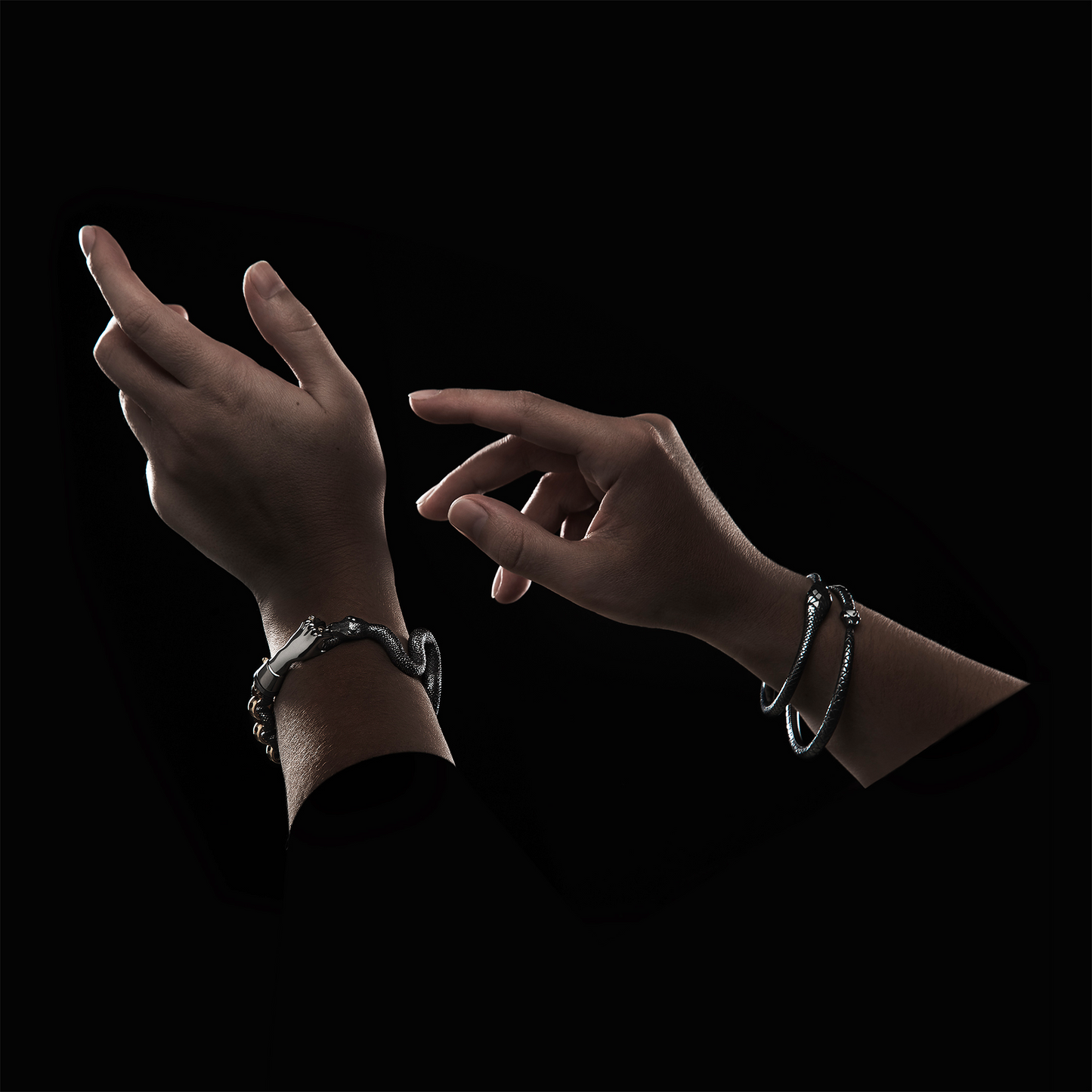 Close-up of snake bracelet with hand clasp in black and gold, luxury craftsmanship detail