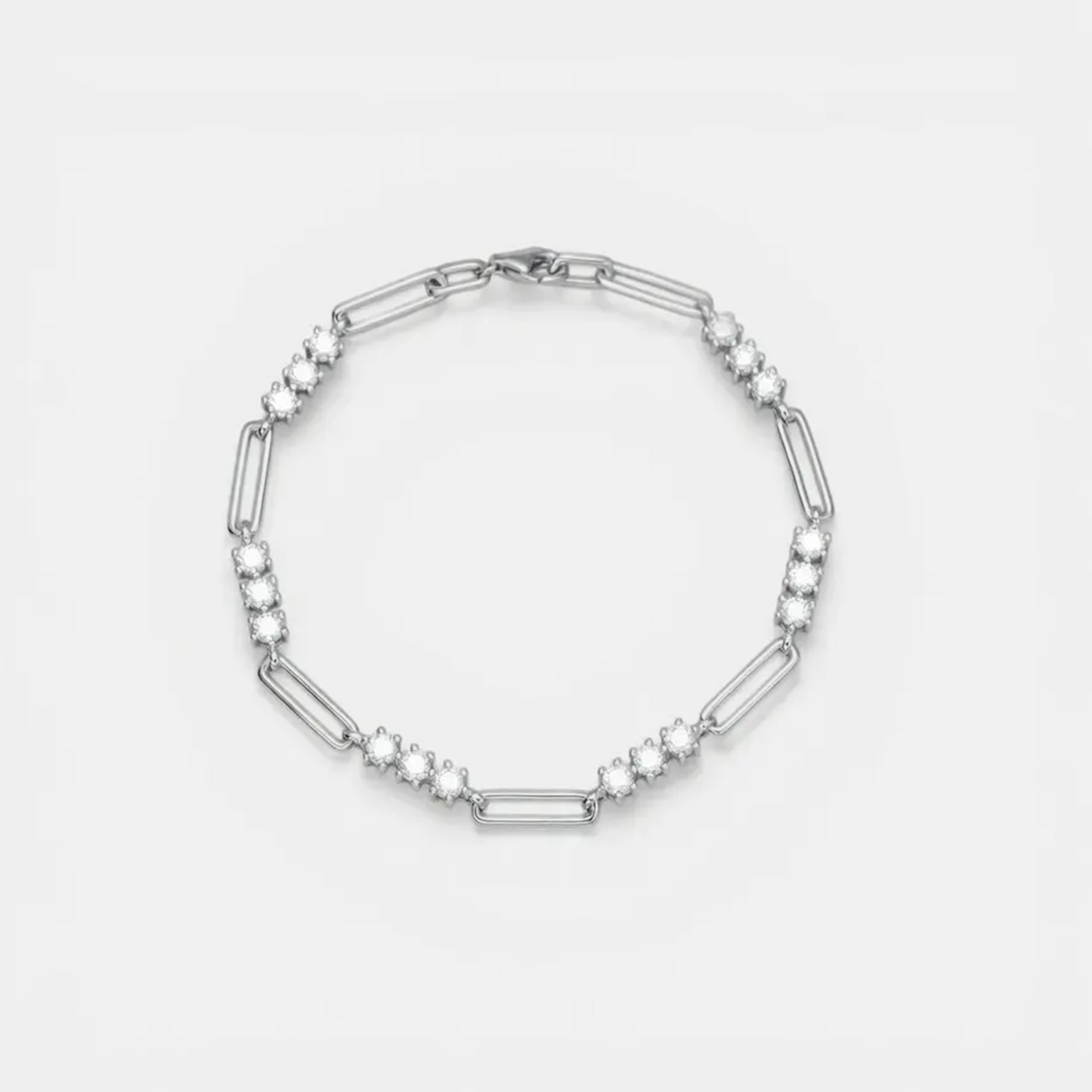 A silver-toned link bracelet featuring alternating elongated oval links and clusters of small round clear stones, displayed on a clean white background.