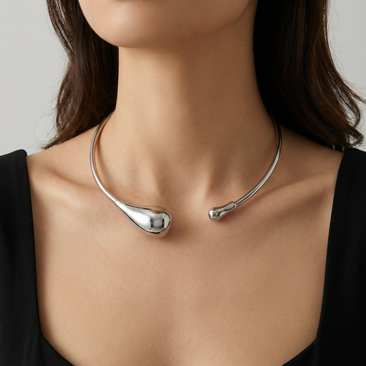 Silver necklace on a model against a neutral background