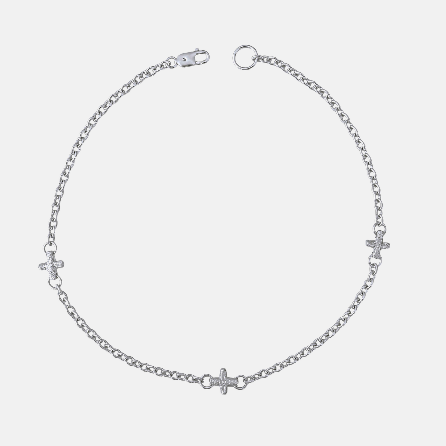 A silver chain anklet featuring three small cross charms and heart charms spaced along the chain, displayed on a light gray background.