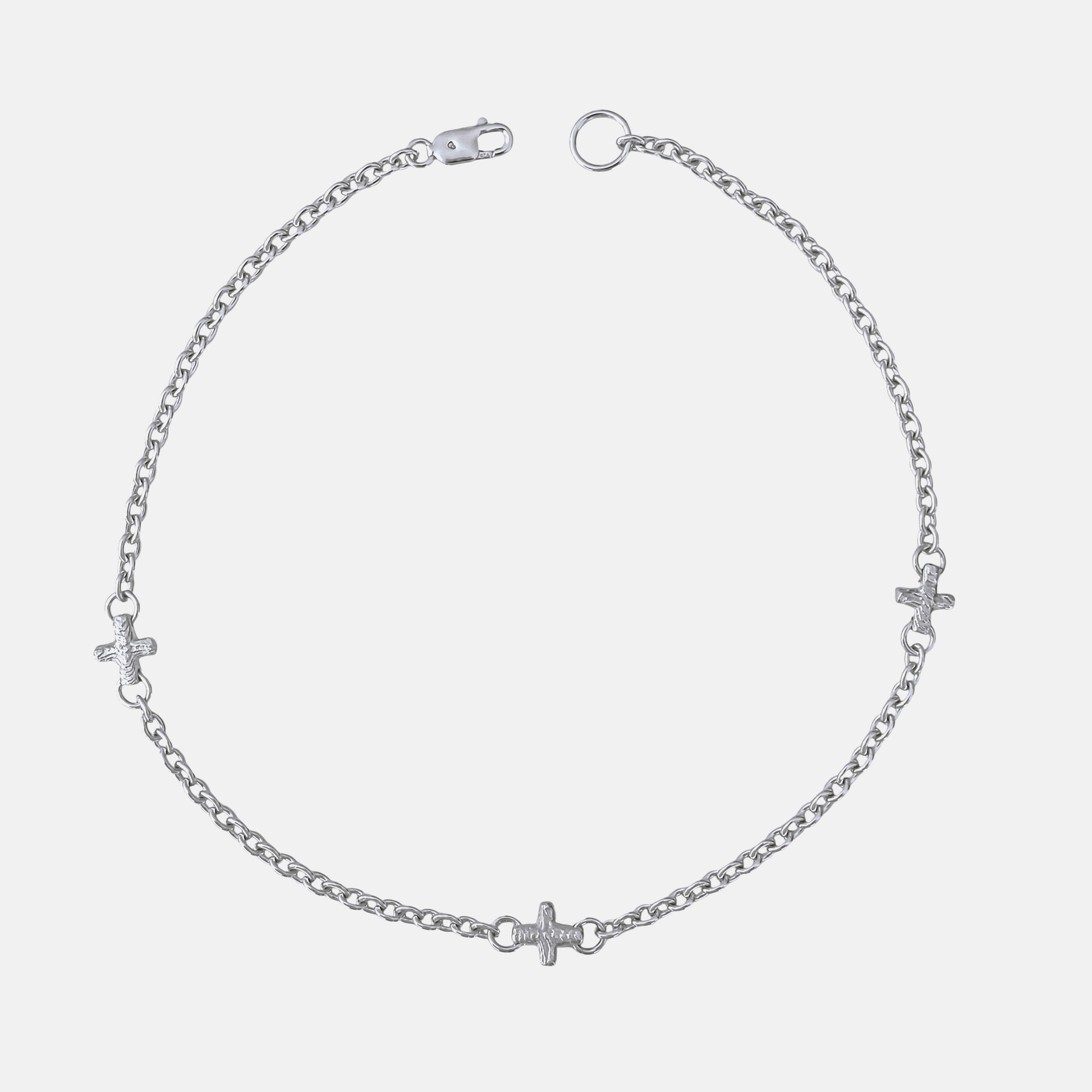 A silver chain anklet featuring three small cross charms and heart charms spaced along the chain, displayed on a light gray background.