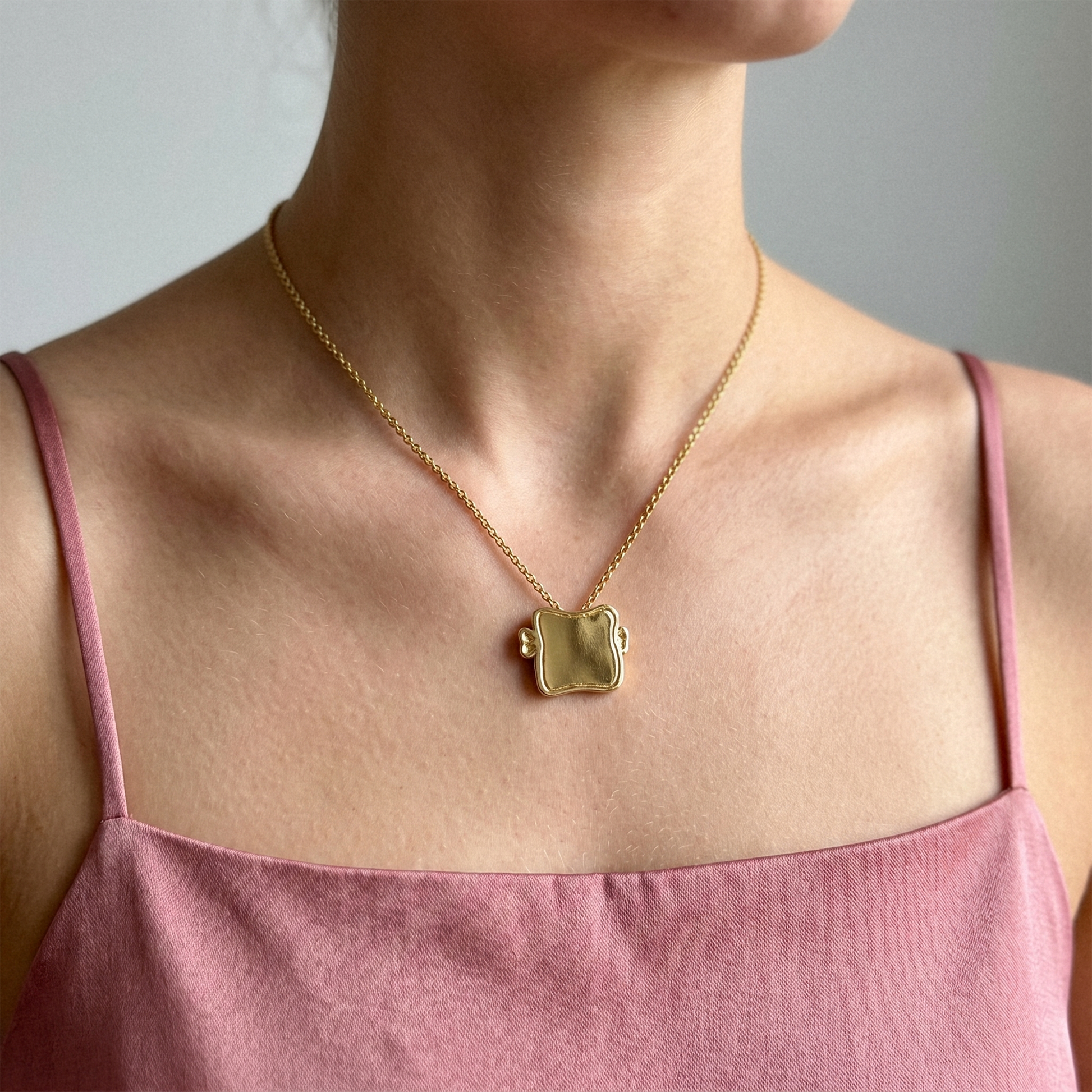 Model wearing the Toast Medal Pendant Necklace in recycled gold
