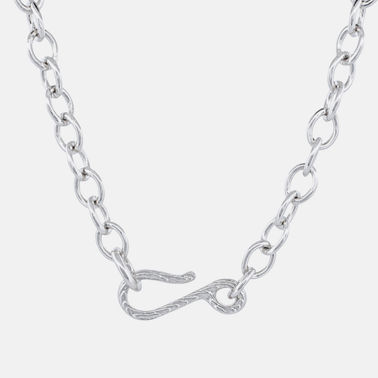 A silver chain necklace featuring a unique twisted infinity symbol clasp, shown against a light gray background.