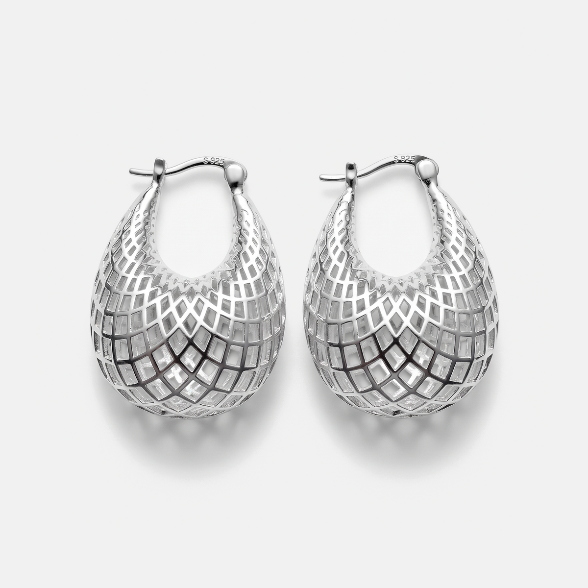 A pair of silver teardrop-shaped hoop earrings with a geometric openwork mesh pattern, displayed on a light gray background.
