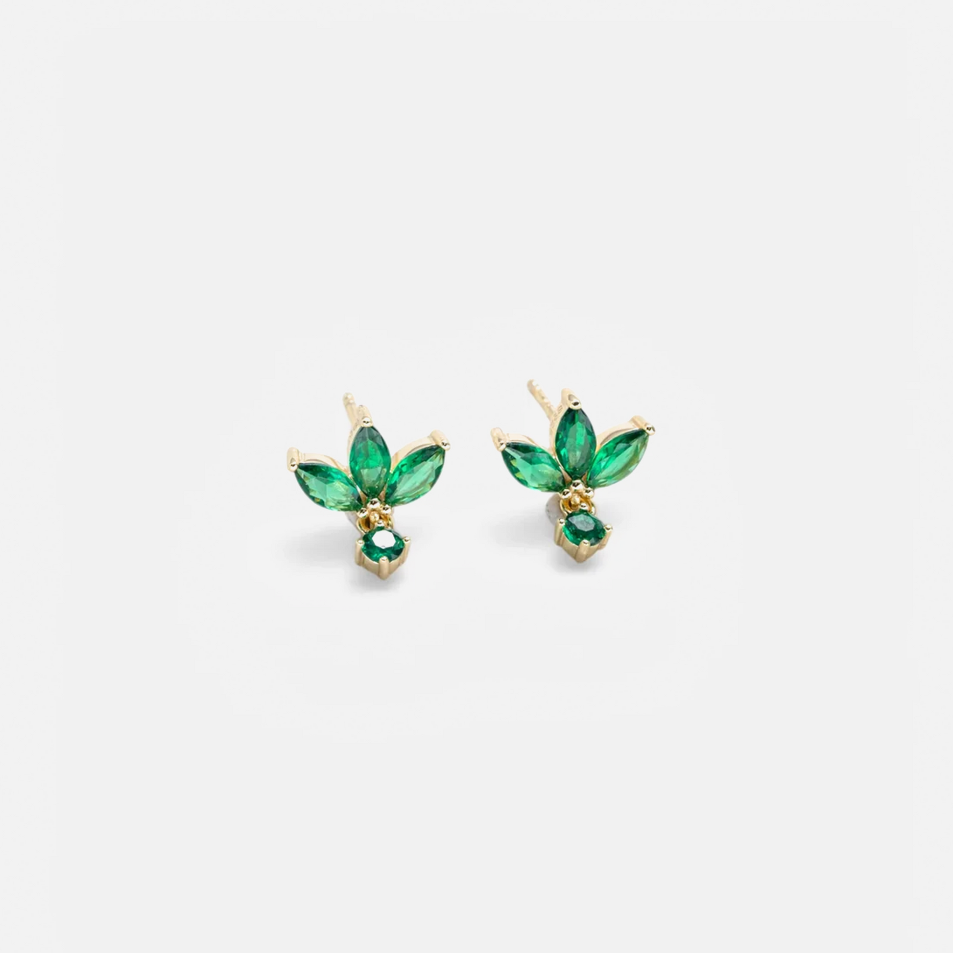 A pair of gold stud earrings featuring marquise-cut green gemstones arranged in a leaf-like cluster with a smaller green stone hanging below, shown on a light gray background.
