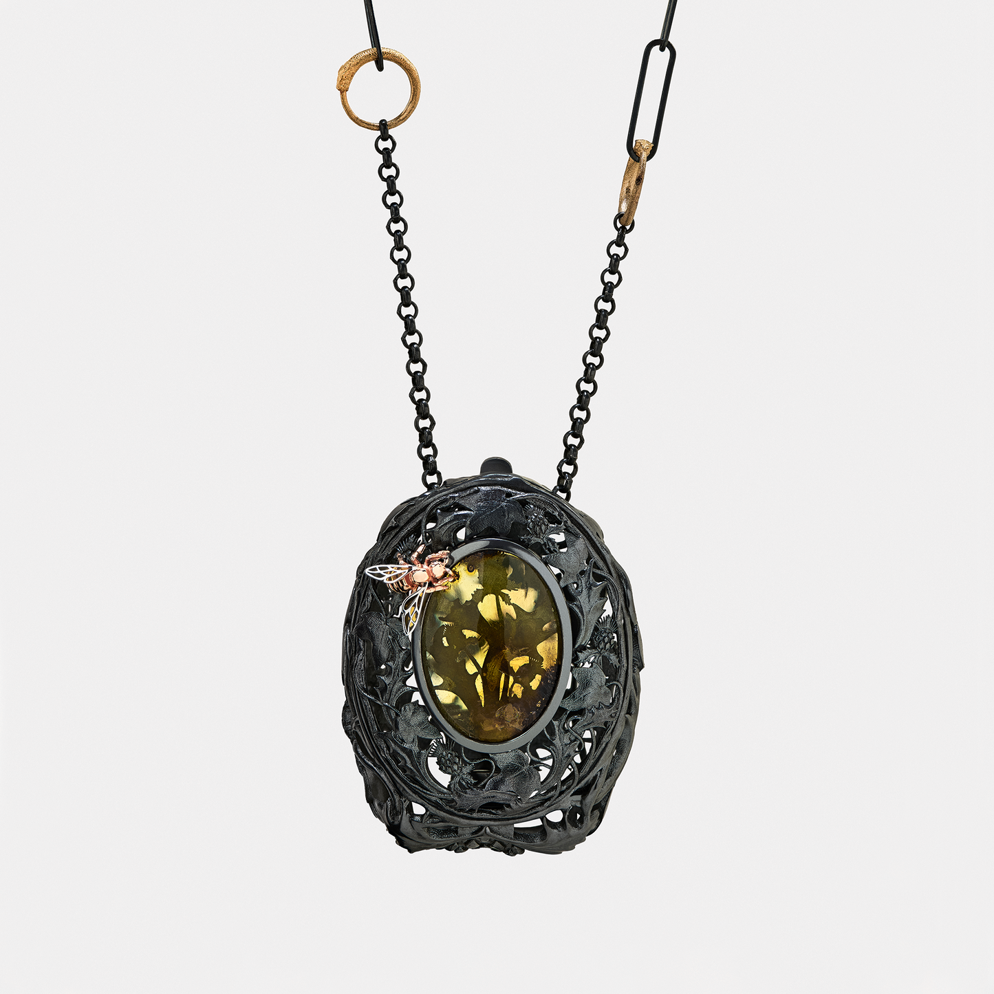 Necklace with a decorative pendant featuring a green gemstone on a white background. A little bag to carry your jewellery