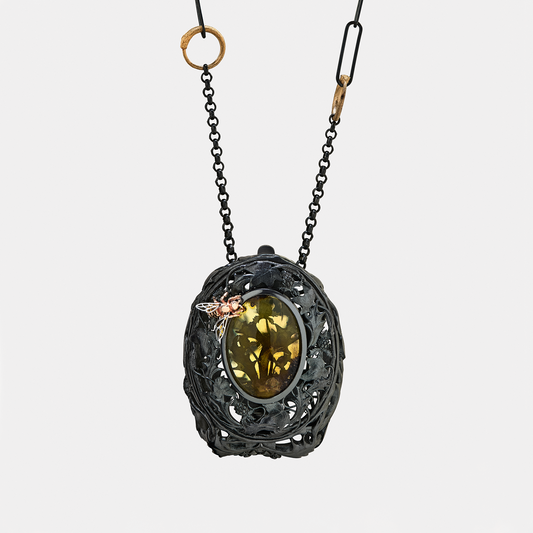 Necklace with a decorative pendant featuring a green gemstone on a white background. A little bag to carry your jewellery