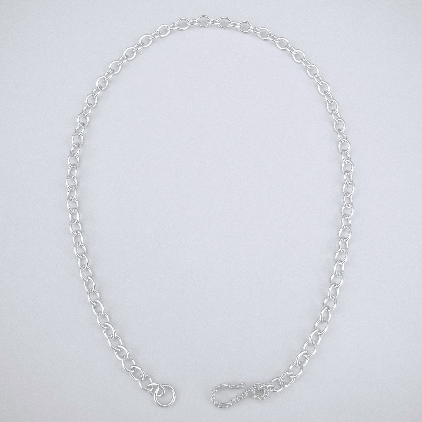 Silver chain necklace on a light gray background
