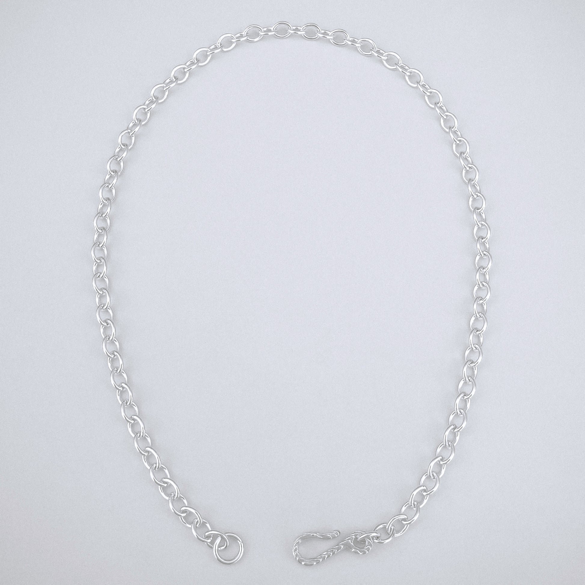 Silver chain necklace on a light gray background