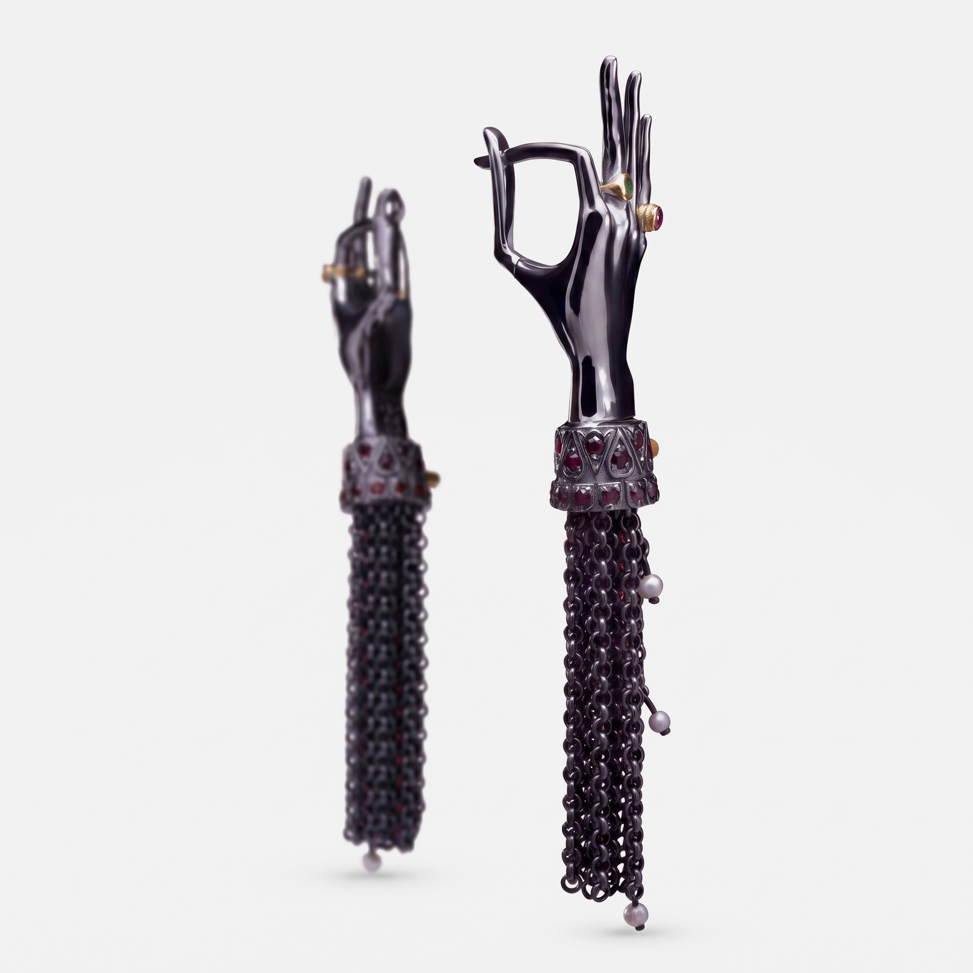 Black hand-shaped earrings with articulated fingers, gemstone details and long chain tassels, contemporary jewellery design