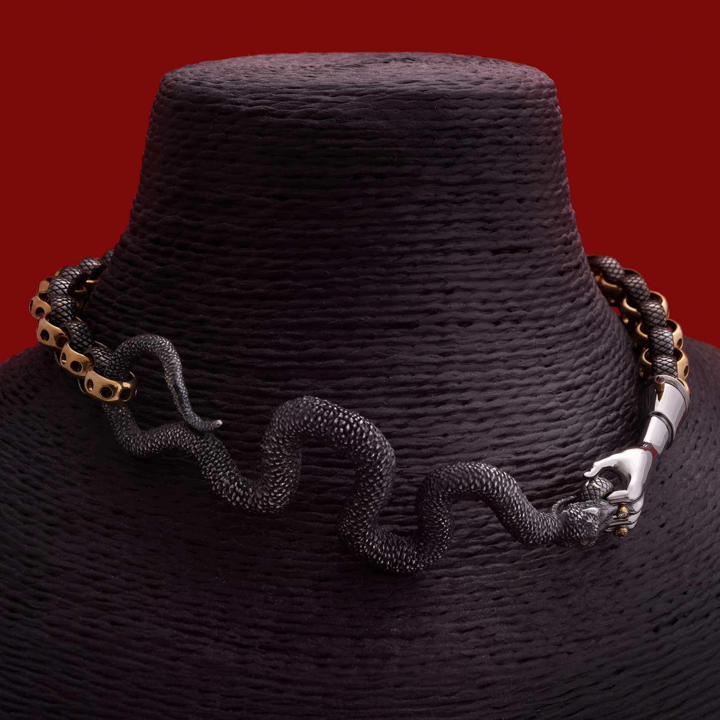 Snake necklace in black and gold worn on neck, statement designer jewellery piece