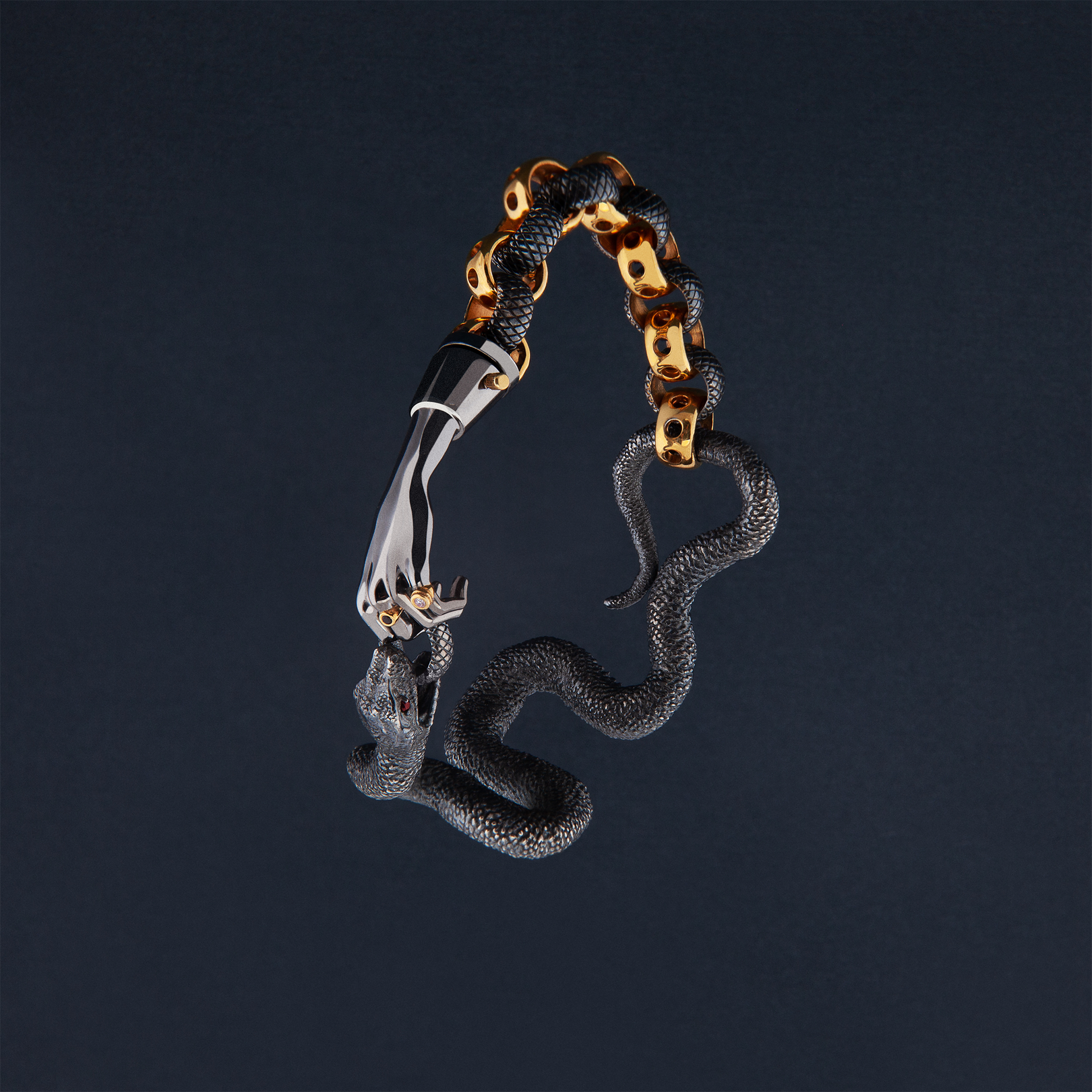 Sculptural snake bracelet in black and gold with hand detail, artistic jewellery design