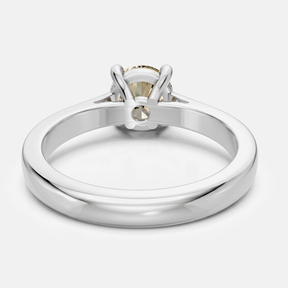 A polished silver-toned ring with a round-cut clear gemstone in a prong setting, shown from the back on a light gray background.