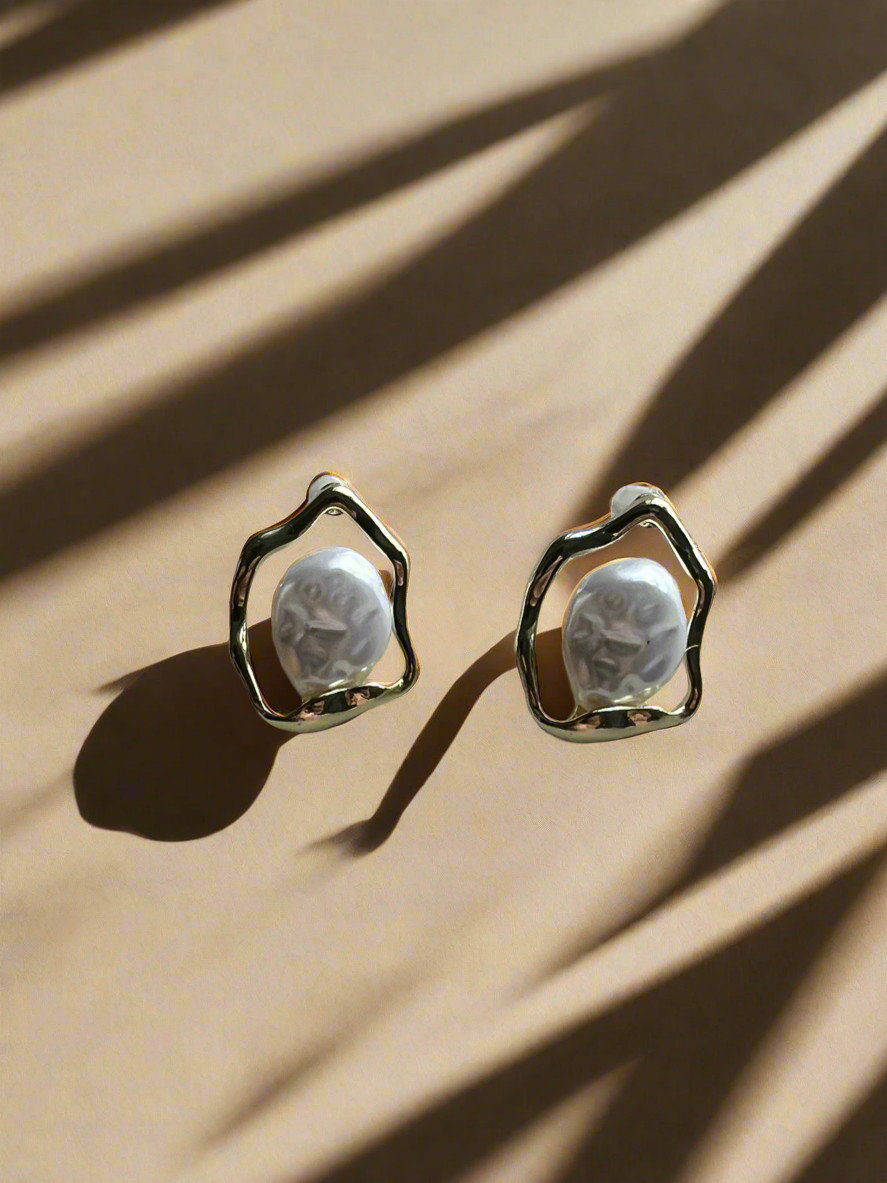 Pair of earrings with a textured design on a beige surface