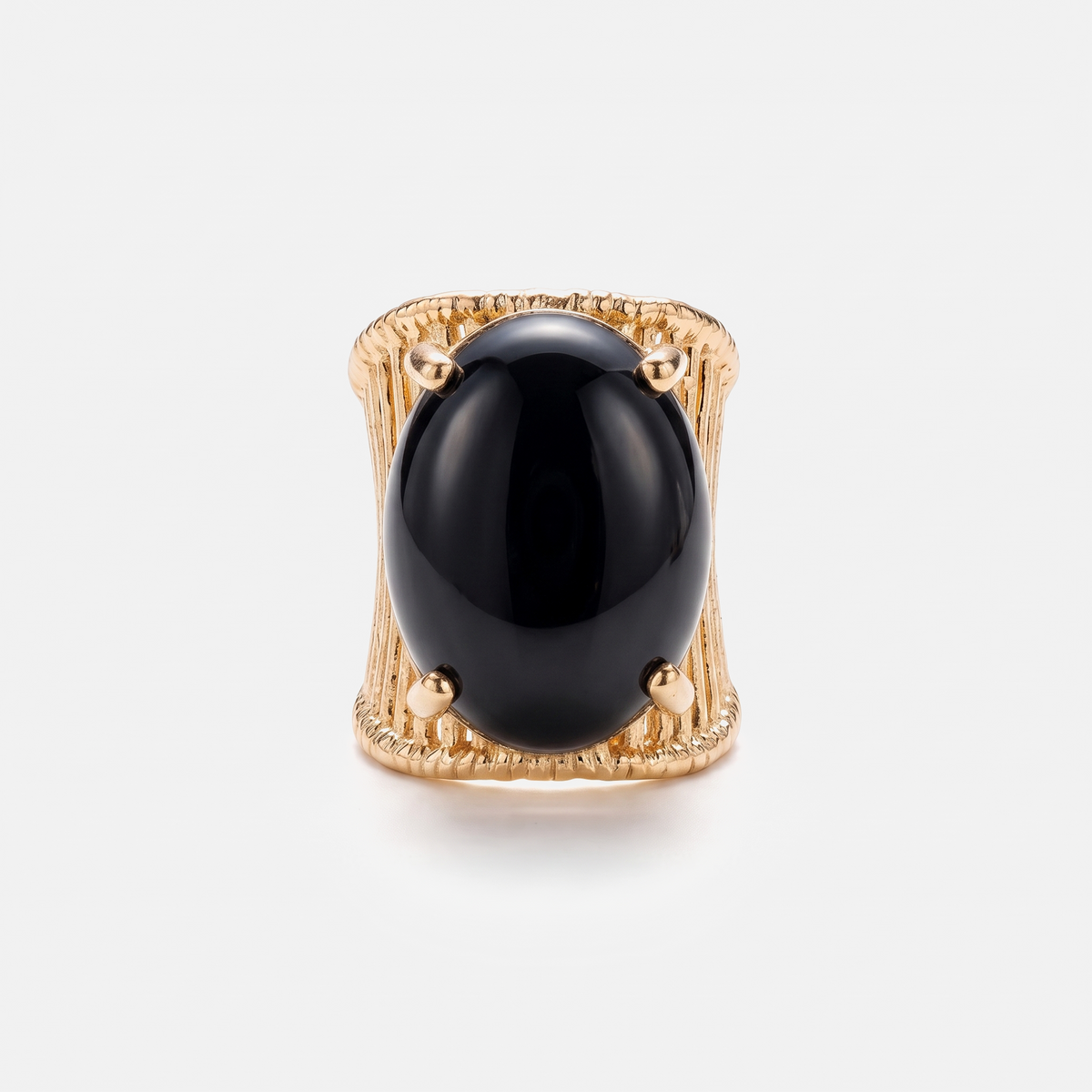 A gold ring featuring a large, smooth, oval black onyx cabochon stone, photographed against a clean, light gray background.