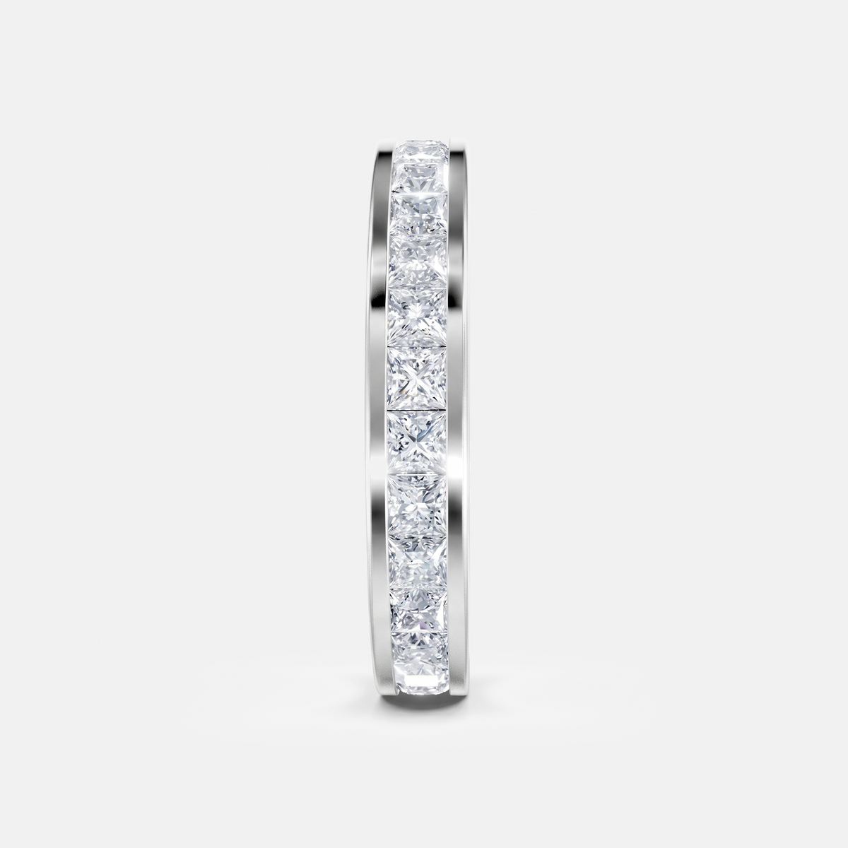 A slim silver band ring featuring a continuous channel setting of clear square-cut diamonds, shown vertically against a light gray background.