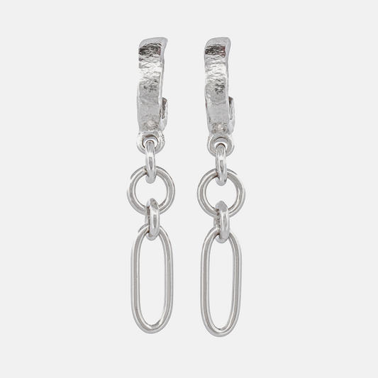 A pair of silver huggie hoop earrings with textured tops and dangling oval links, shown on a light gray background.