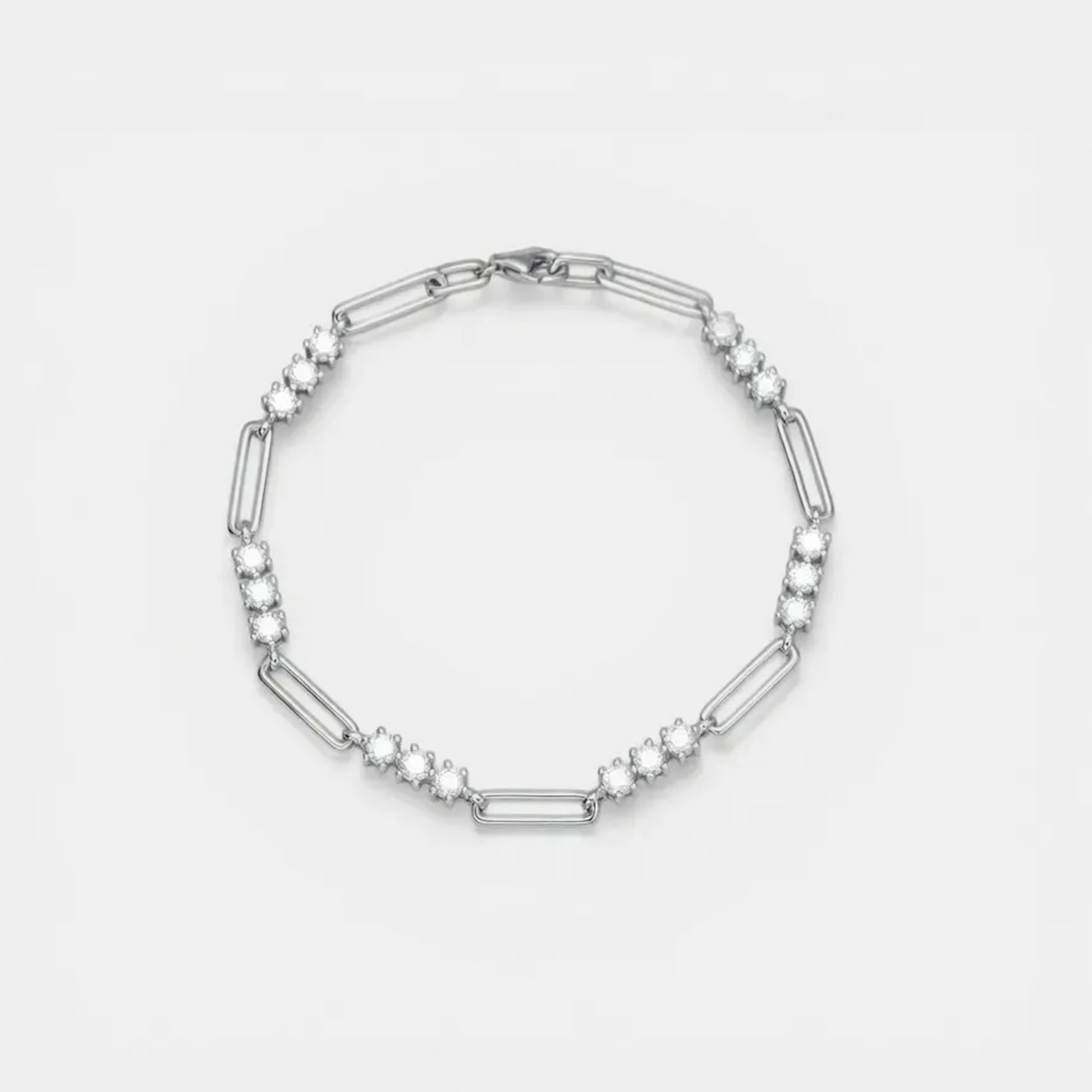 A silver-toned link bracelet featuring alternating elongated oval links and clusters of small round clear stones, displayed on a clean white background.