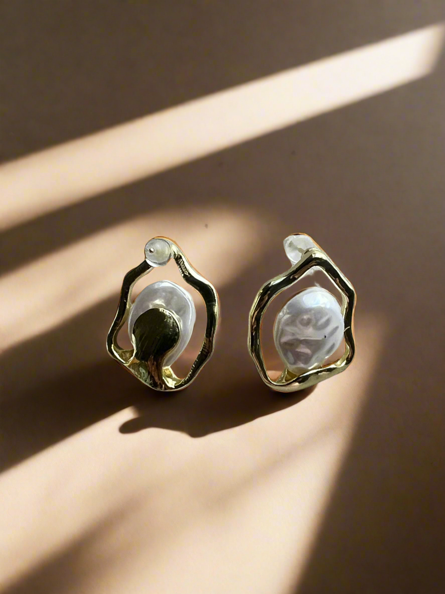 Pair of earrings with a textured design on a beige surface