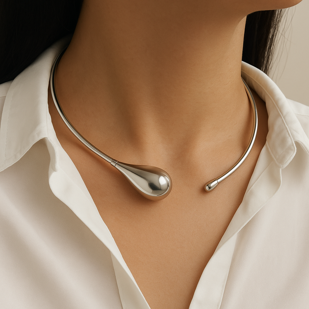 Silver necklace worn by a person with a white shirt