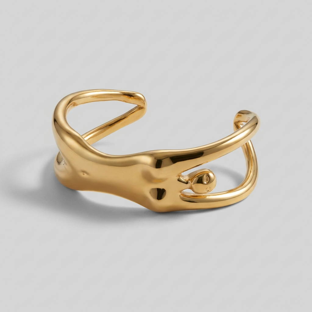 Gold open cuff bracelet on a light gray background