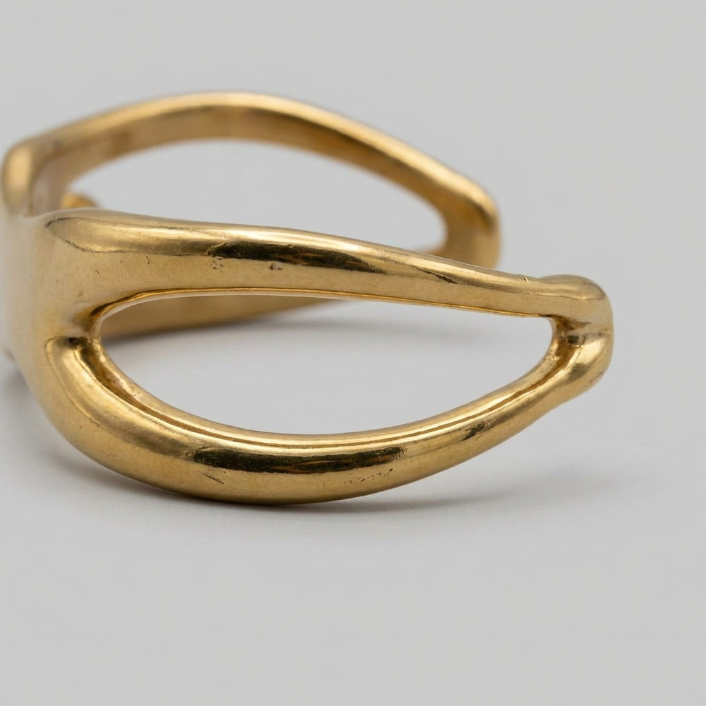 Gold open cuff bracelet on a light gray background