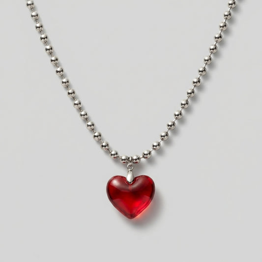Necklace with a red heart pendant on a light gray background