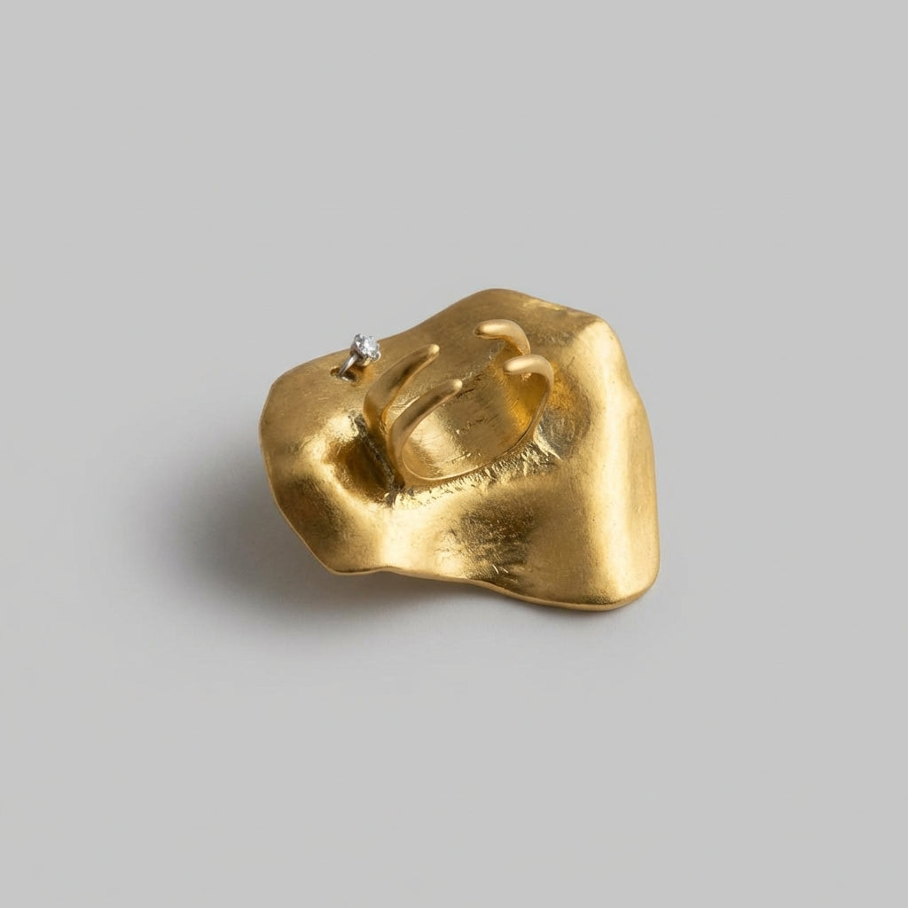 Gold ring with eye design on a gray background