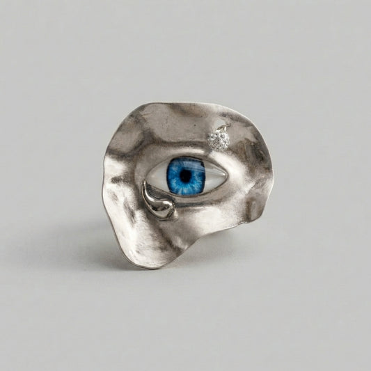 Silver ring with a blue gemstone on a gray background