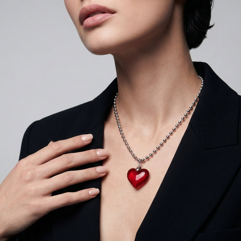 Necklace with a red heart pendant on a light gray background