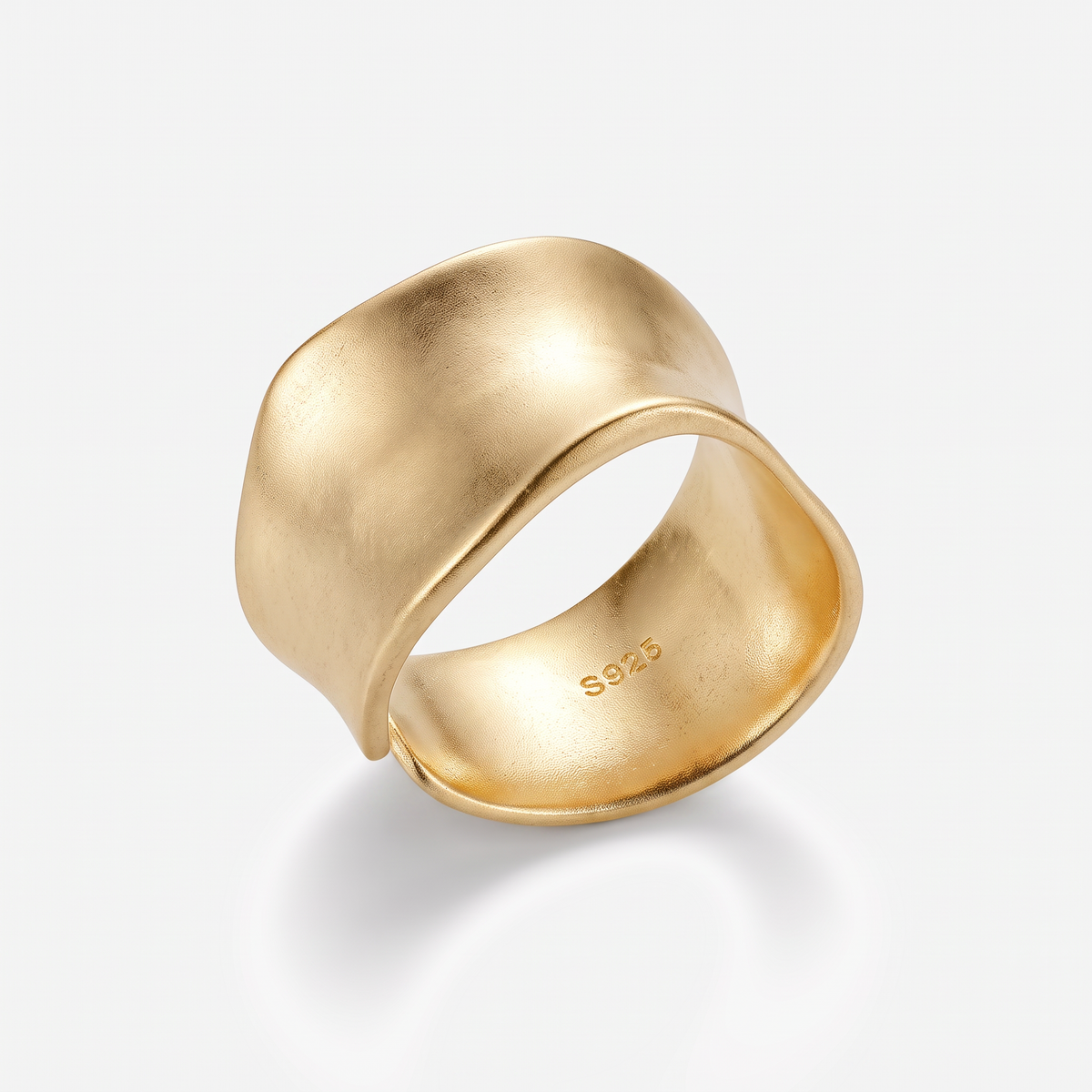 A wide, abstract gold ring with a matte finish and a polished inner band, featuring a 'S925' sterling silver hallmark, shown on a light gray background.